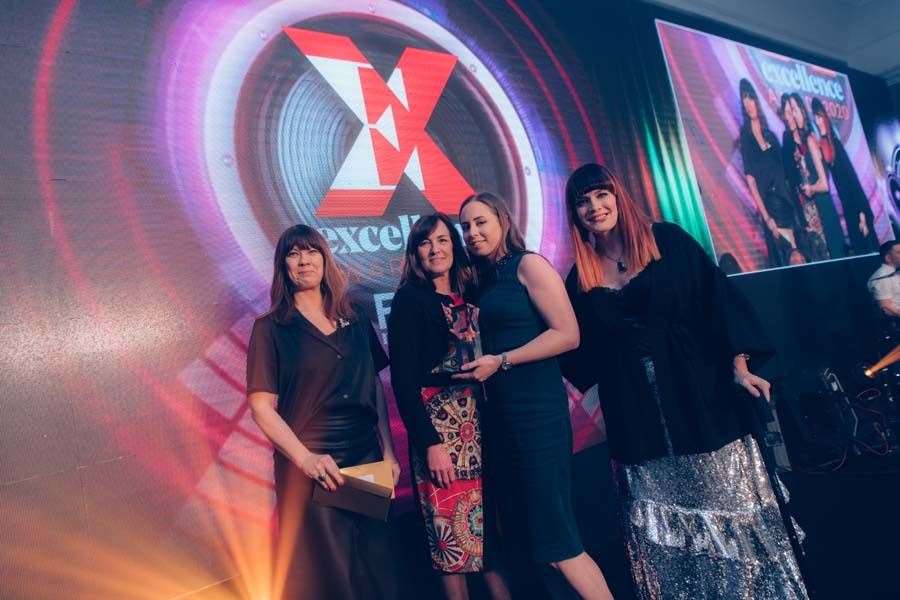 Fudge Kitchen MD Sian Holt and production manager Arianne Mills (centre left, and right) pick up the award