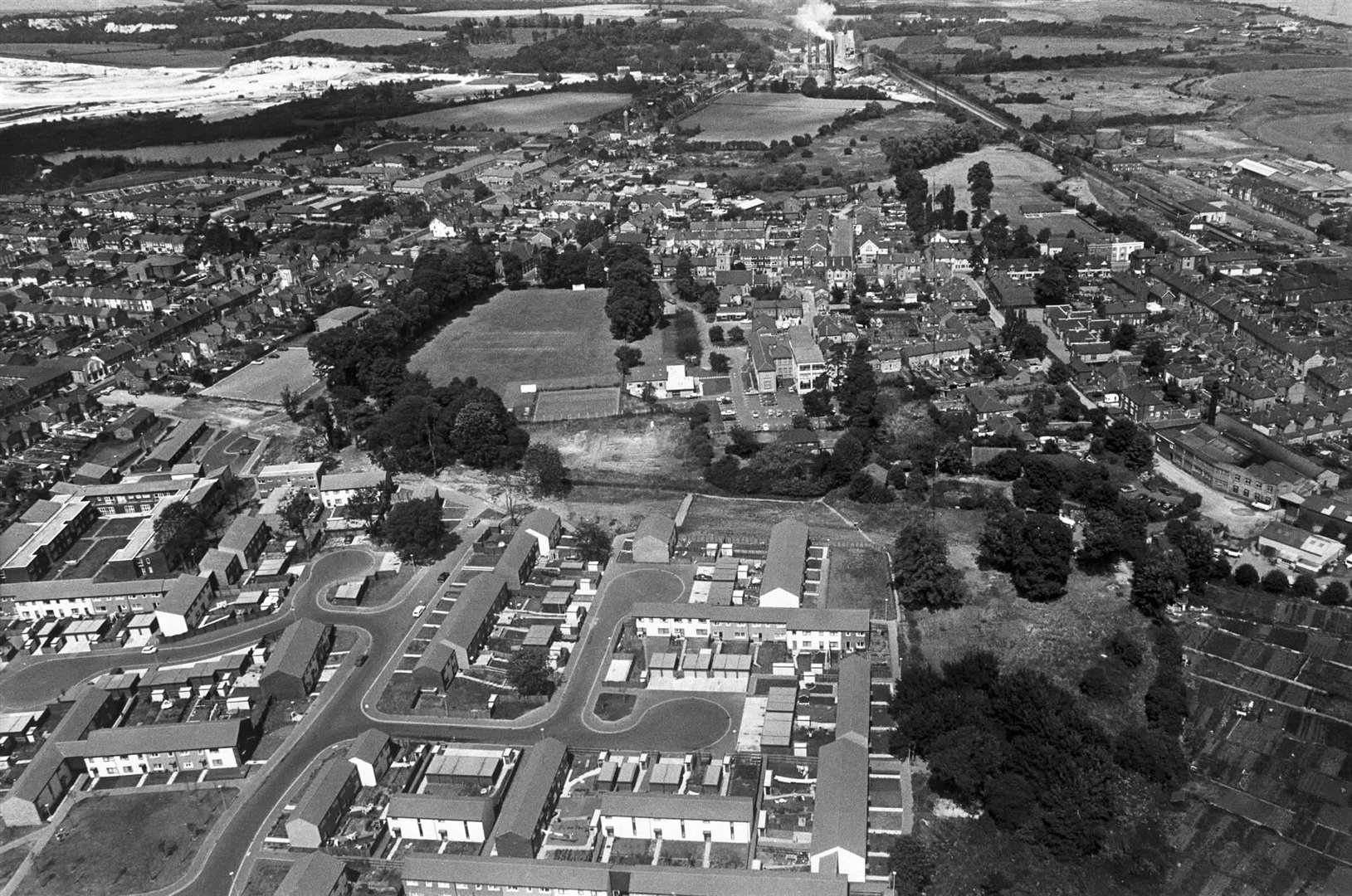A view from August 1978 looking over Snodland. Old people's homes can be seen on the left in Rectory Close, with Saltings Road in the foreground, part of the Ham Hill estate, the cricket ground in the centre, Holborough cement works at the top and railway line and station to the right.