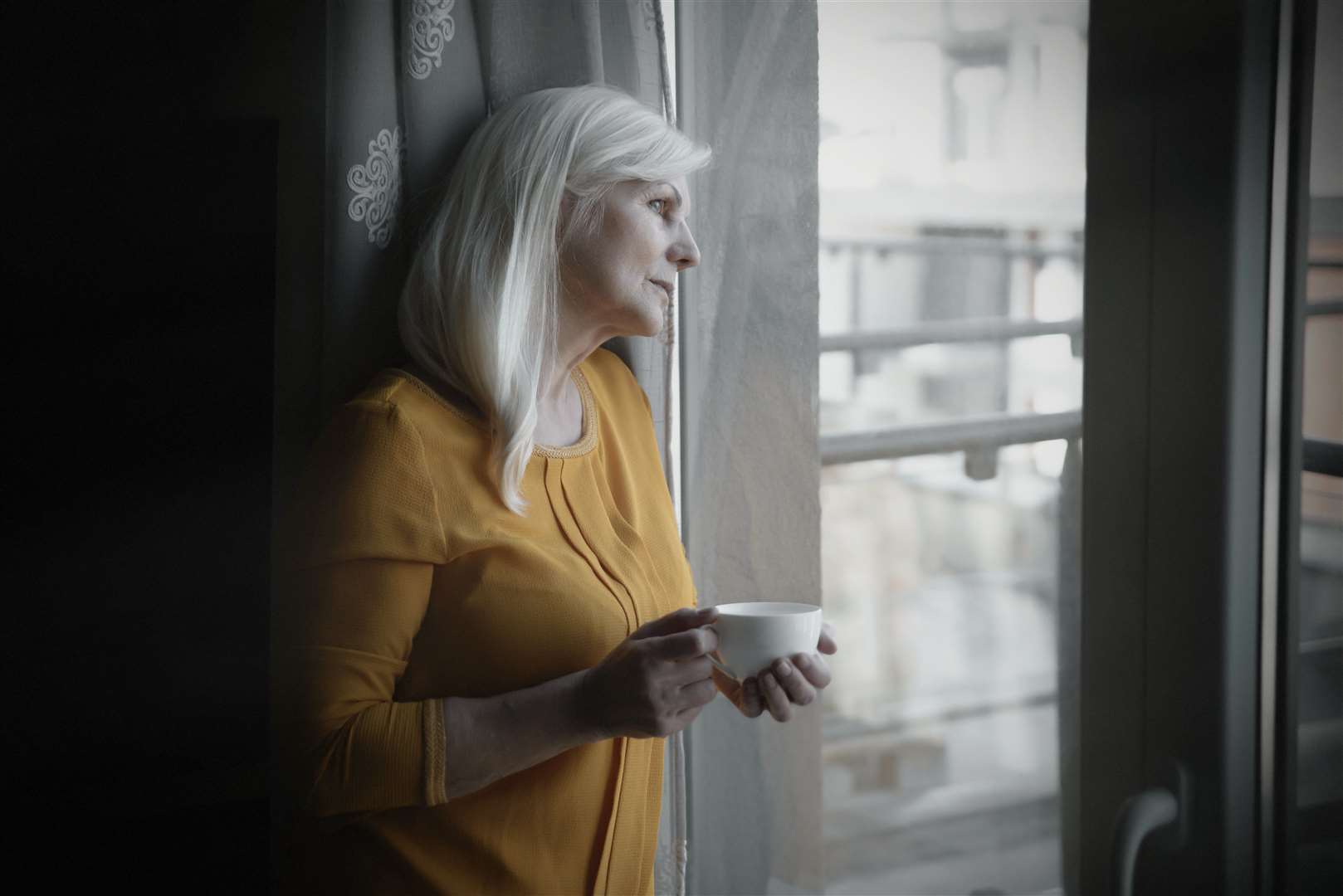 Depressed senior woman near window at home. (48105616)