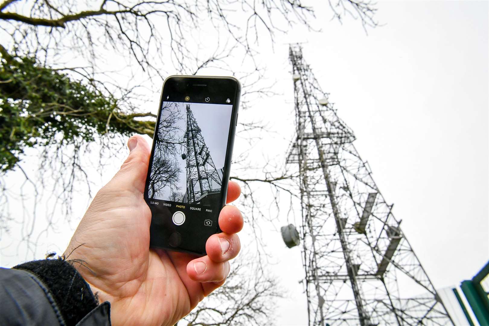 A mobile phone next to a telecoms mast (Ben Birchall/PA) 