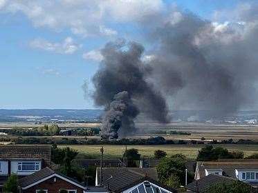Black smoke rises into the air from a caravan fire in Greyhound Road, Minster. Picture: Louise McLaren