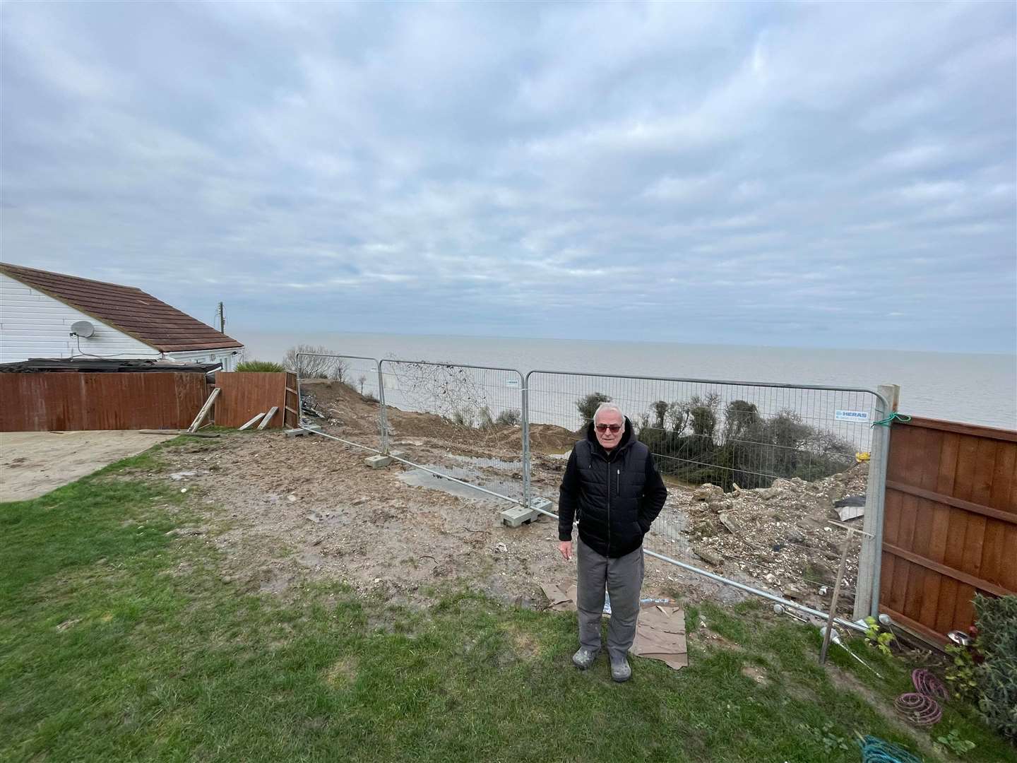 Ed standing in his back garden, of which he has lost at least 18ft since the cliff collapse in 2020
