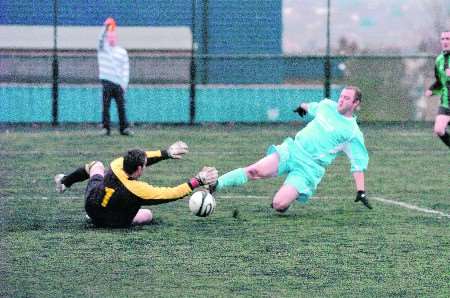 A Castle Tavern (blue) attacker attempts to beat the Swale Athletic goalkeeper to the ball