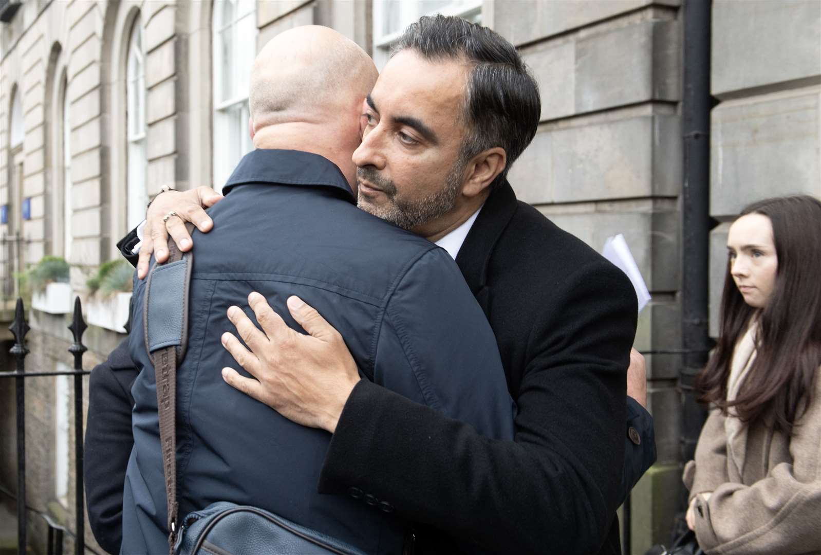 Alan Inglis (left) and Aamer Anwar embrace before a hearing at the Covid-19 pandemic inquiry at George House in Edinburgh (Lesley Martin/PA)