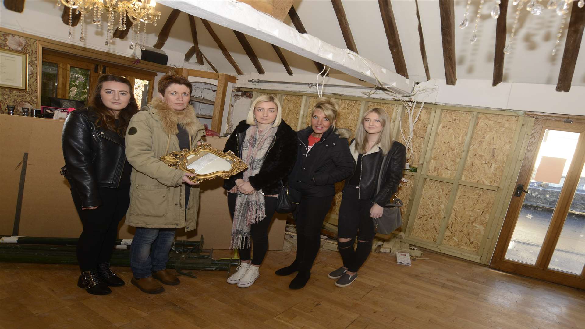 Owner Jenny Taylor and staff by the boarded up window