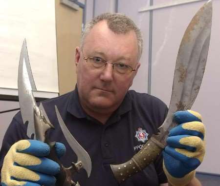 Property officer Pete Boast with two of the knives handed in at Folkestone Police Station. Picture: DAVE DOWNEY