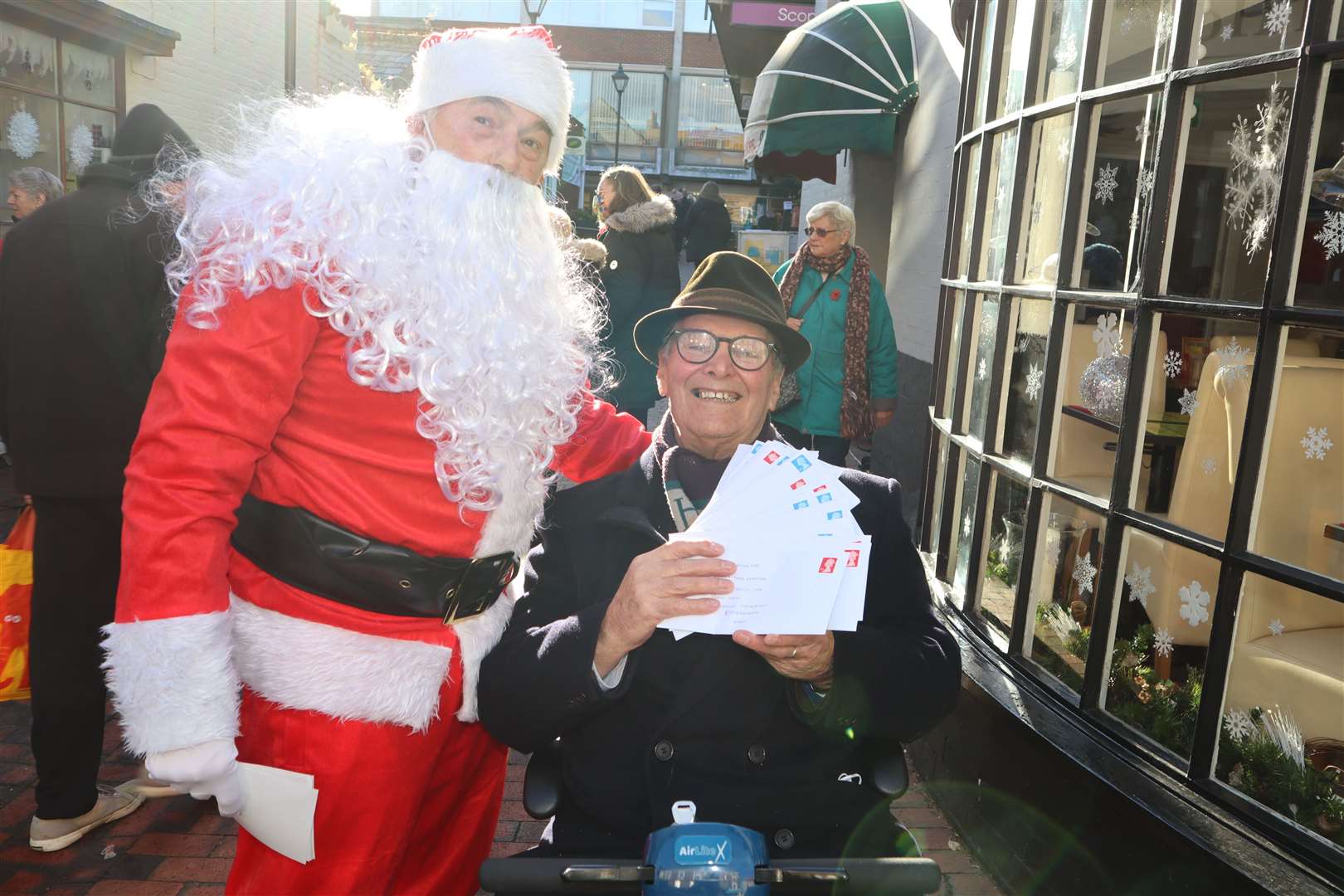 Sittingbourne's 'whistling postman' Dale Howting, pictured with some of cheques he will be posting, along with Santa Mike Day from the Methodist church