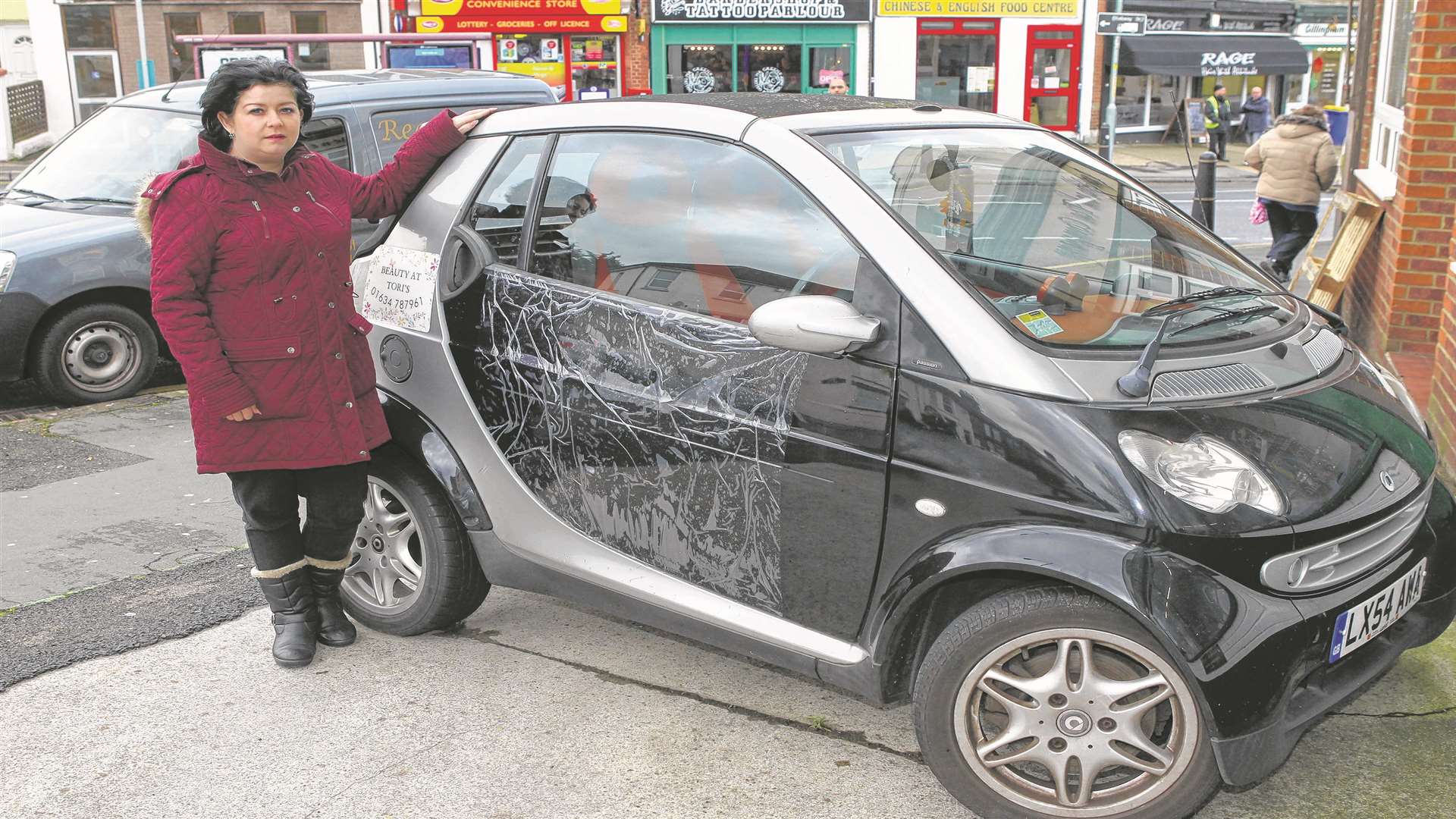 Tori Cobbold with her smart car after the smashed window was replaced.