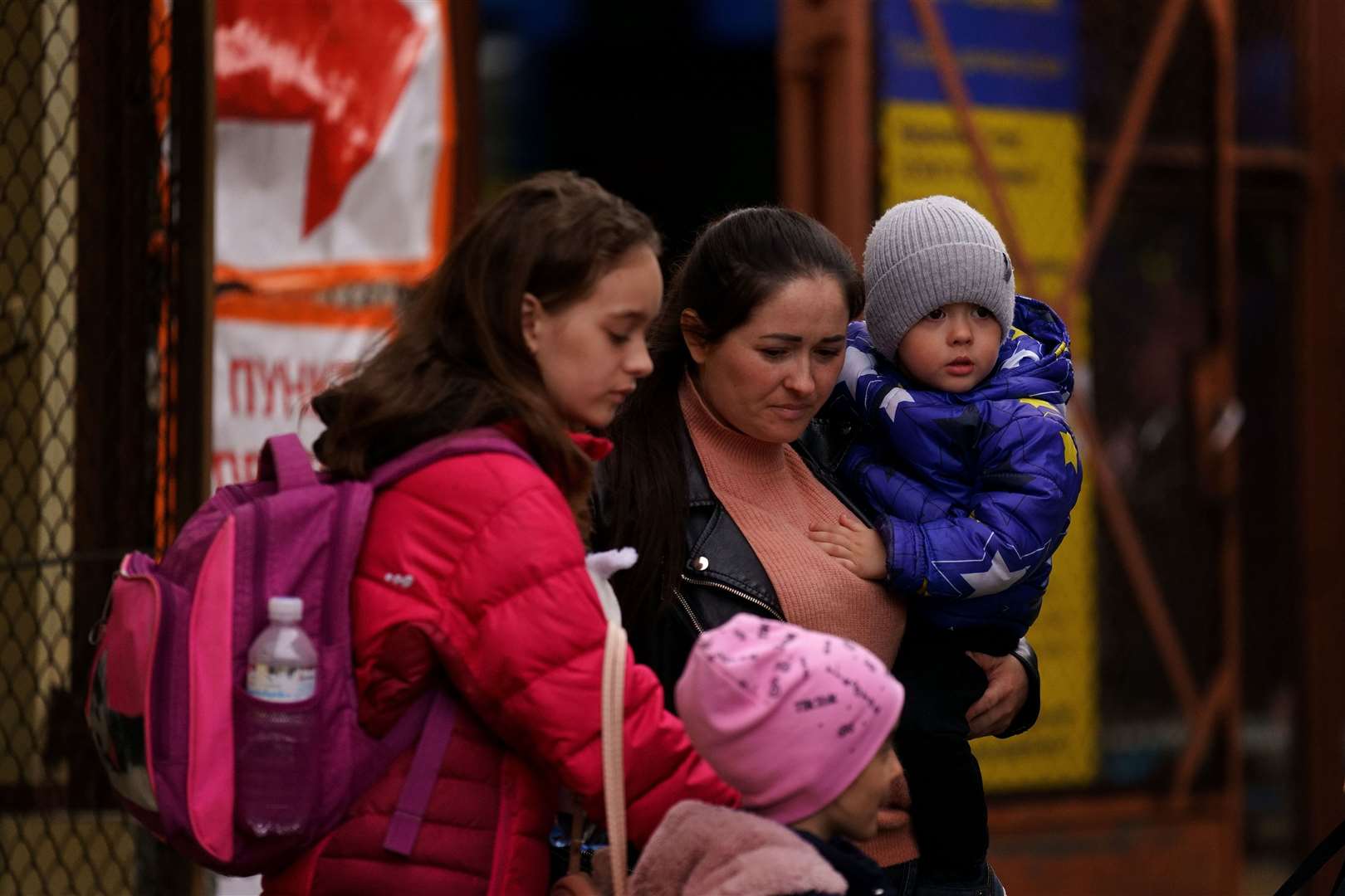 A Ukrainian family walk out of the customs office at Przemysl Glowny train station in Poland (Victoria Jones/PA)
