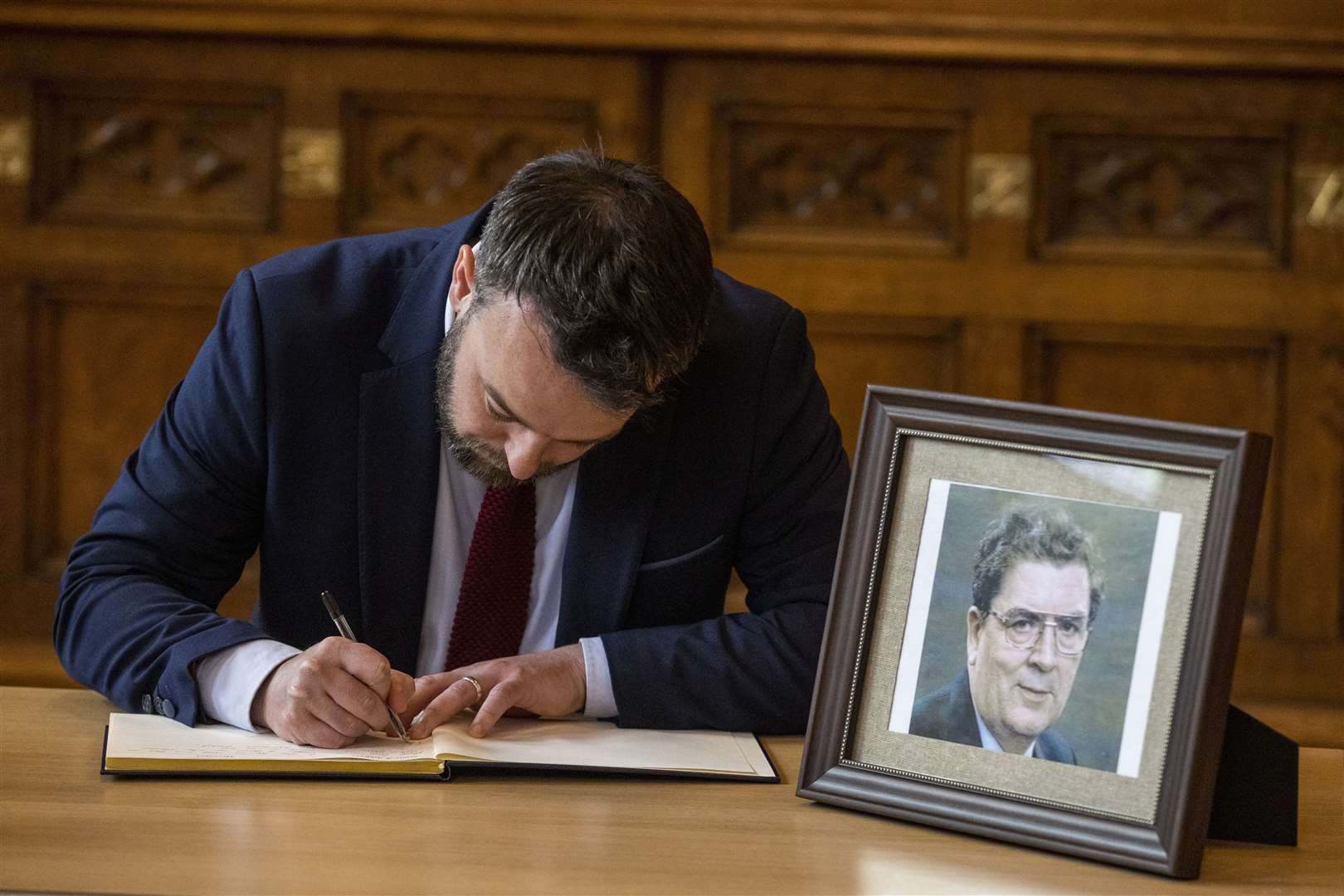 Colum Eastwood signing a book of condolence at Guildhall in Derry (Liam McBurney/PA)
