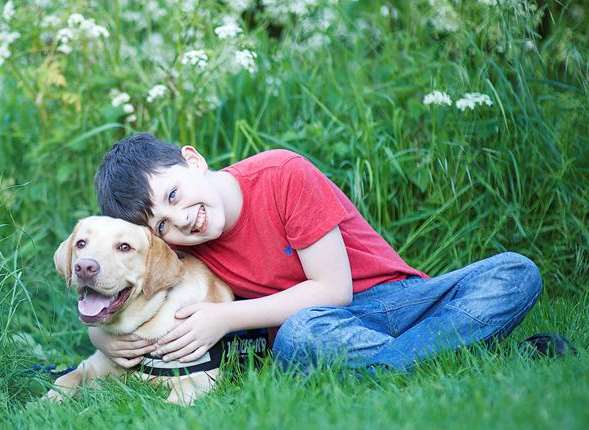 Buddy the golden with 10-year-old Jacob Baker who has autism