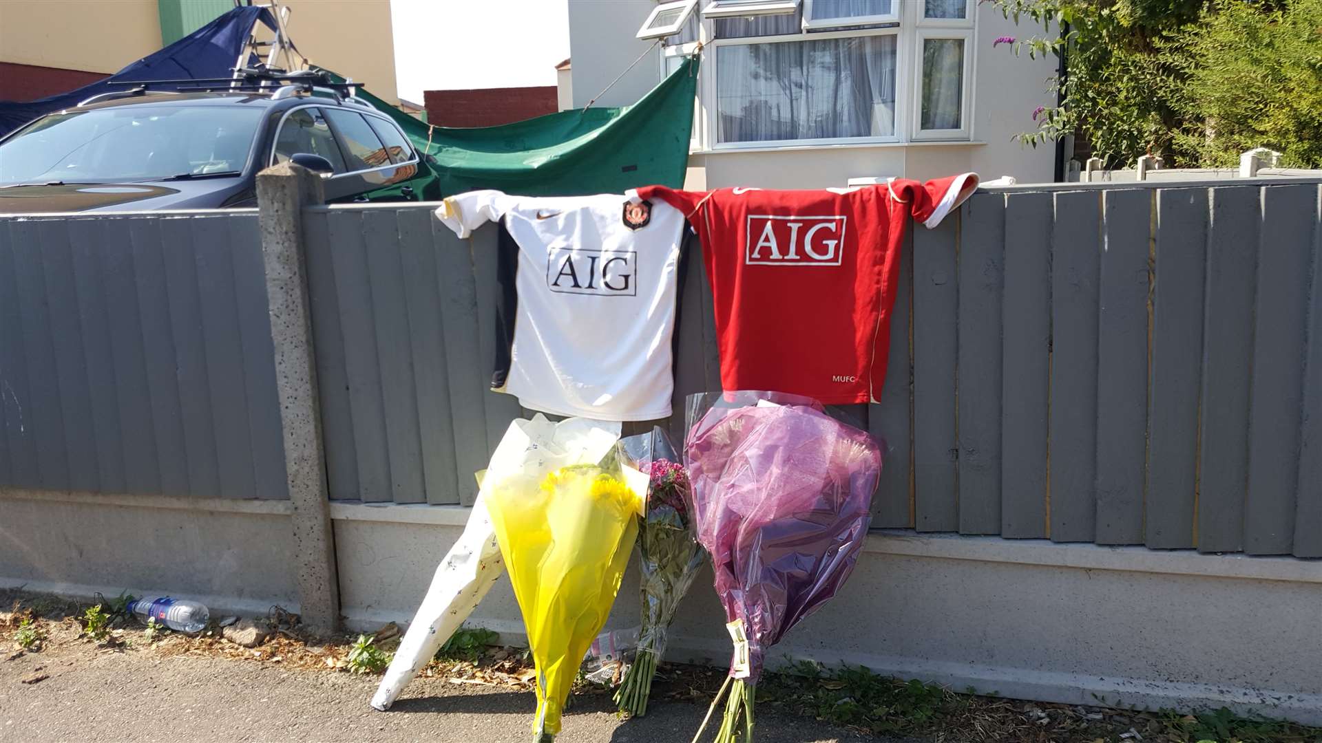 Football shirts and floral tributes were left outside a house