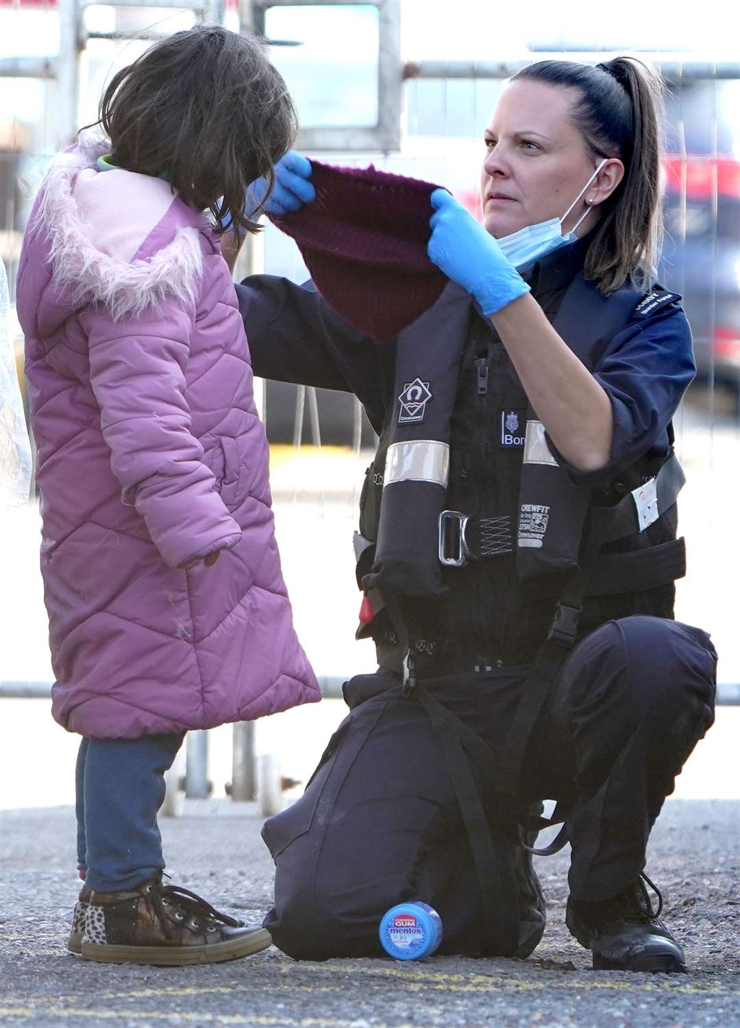 A young girl is helped by a Border Force officer as a group of people thought to be migrants are brought in to Dover, Kent, following a small boat incident in the Channel (Gareth Fuller/PA)