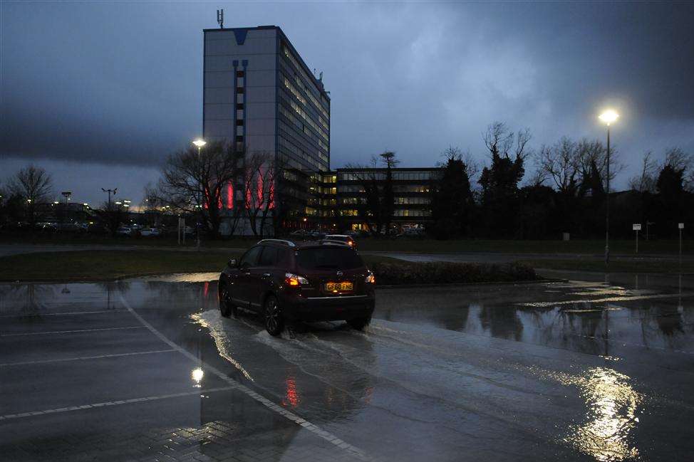 Storm clouds gather over International House and the partially flooded Stour Centre car park