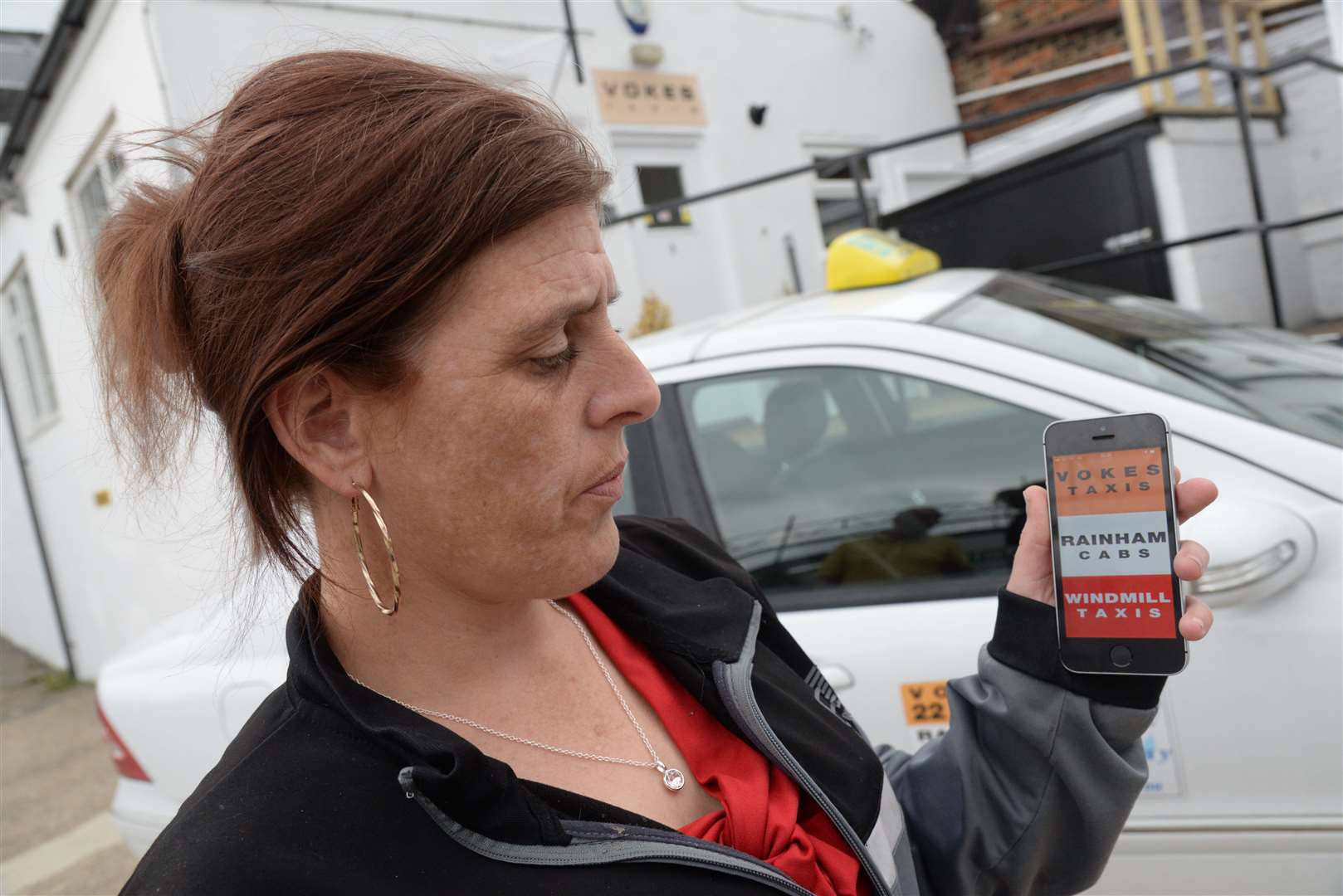 Marie Greenwood demonstrates the new app for Vokes Taxis in Chatham. Picture: Chris Davey