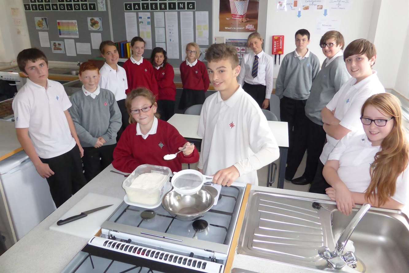 Jessica Pope, 12, and Daniel Martins, 15, prepare their Kent Cooks dishes, watched by pupils at the North School, Ashford.
