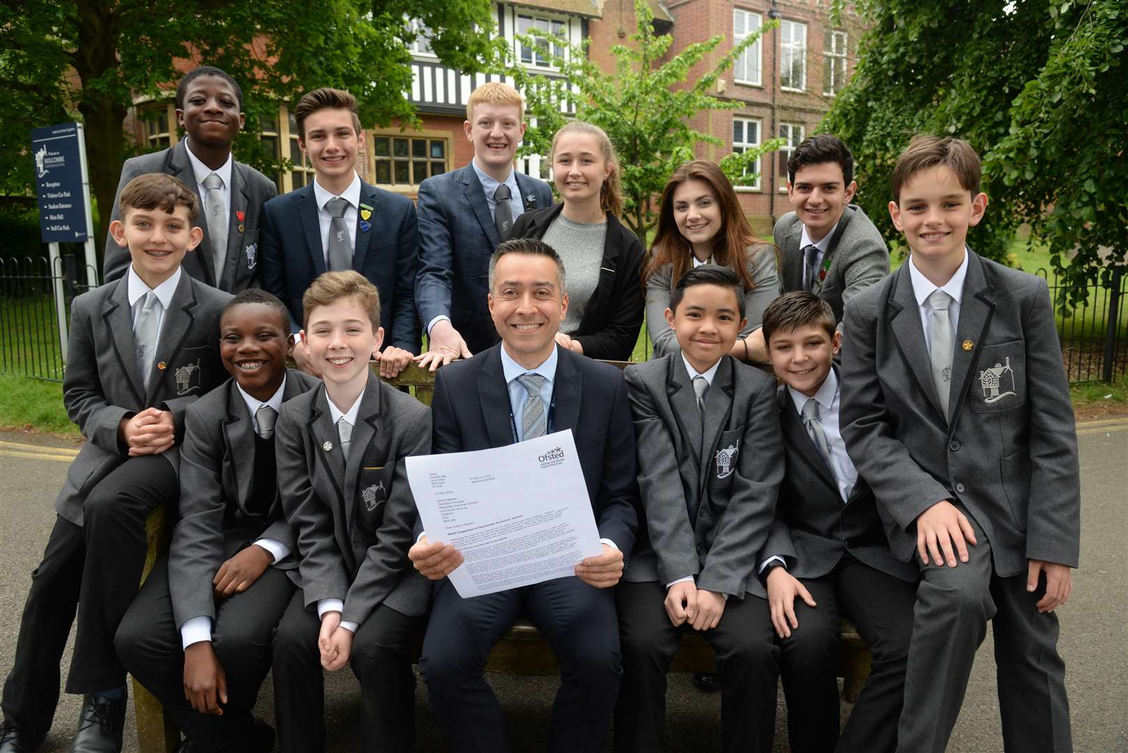 Executive Principal Gwynn Bassan and some of his pupils read through Holcombe Grammar Schools good Ofsted report. Picture: Chris Davey (2228425)
