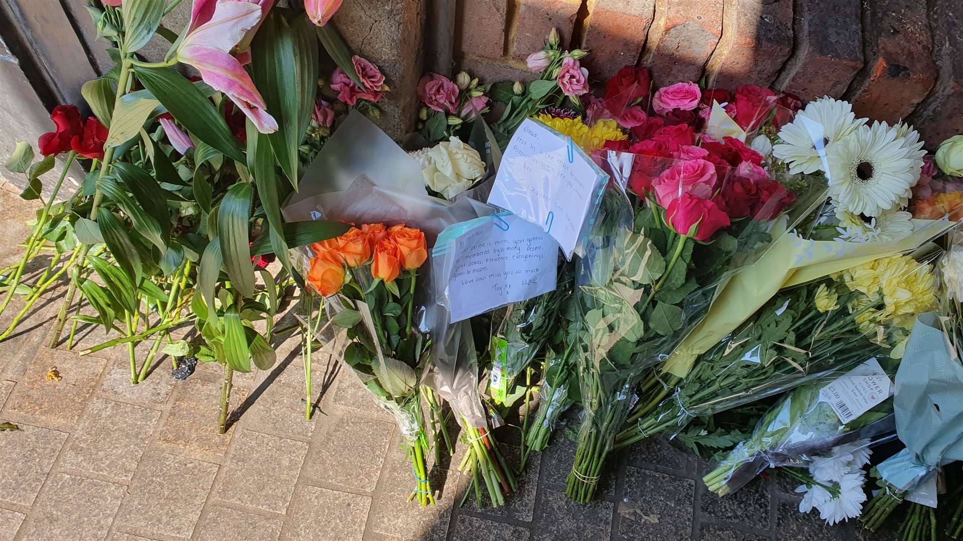 Tributes to an 18-year-old stabbing victim line the alleyway in Dartford High Street