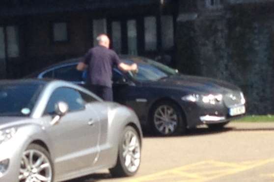Colin Carmichael is pictured removing the parking ticket from his windscreen