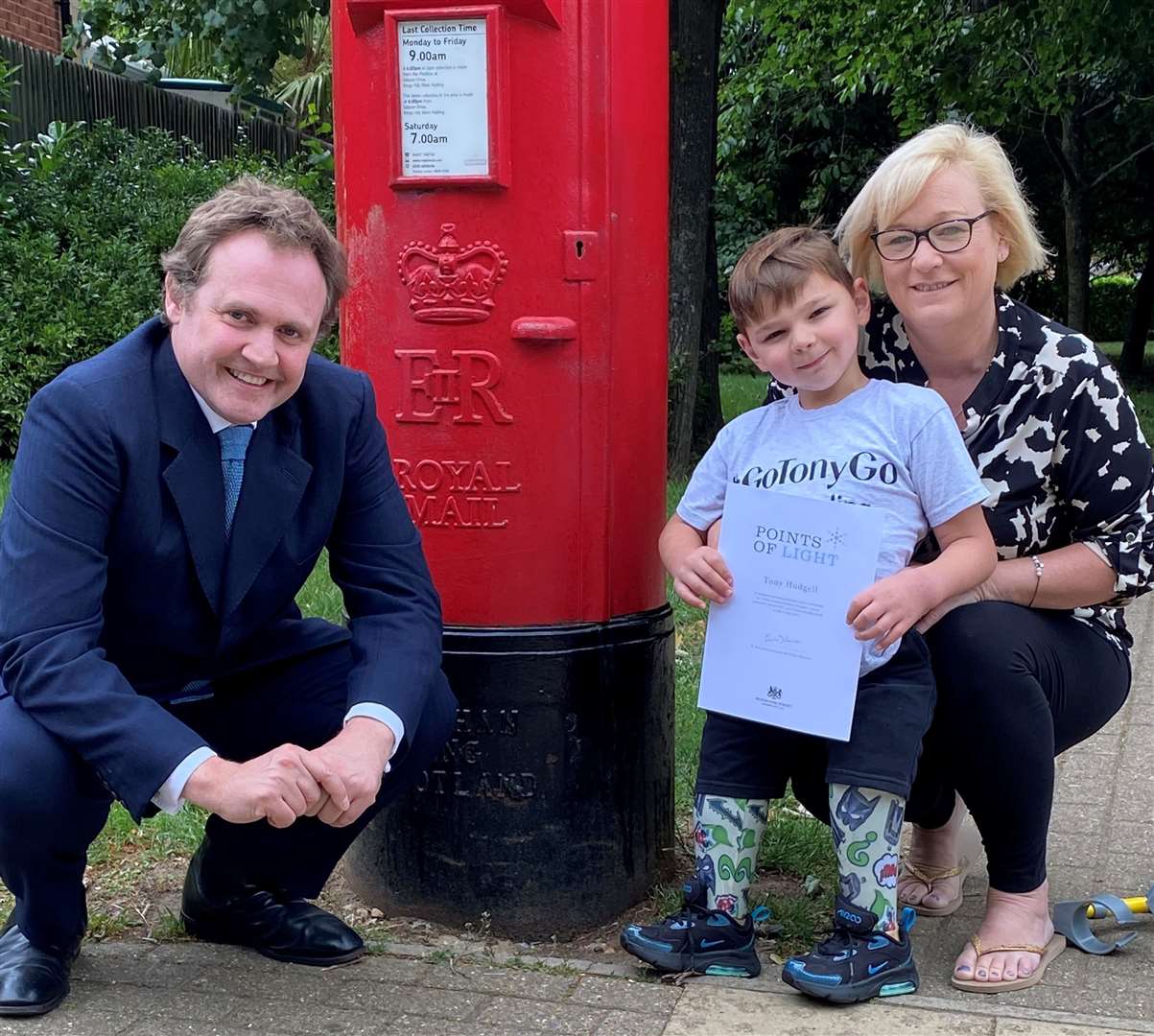 MP Ton Tugendhat presents Tony, pictured with his mum Paula, with a reward from the Prime Minister