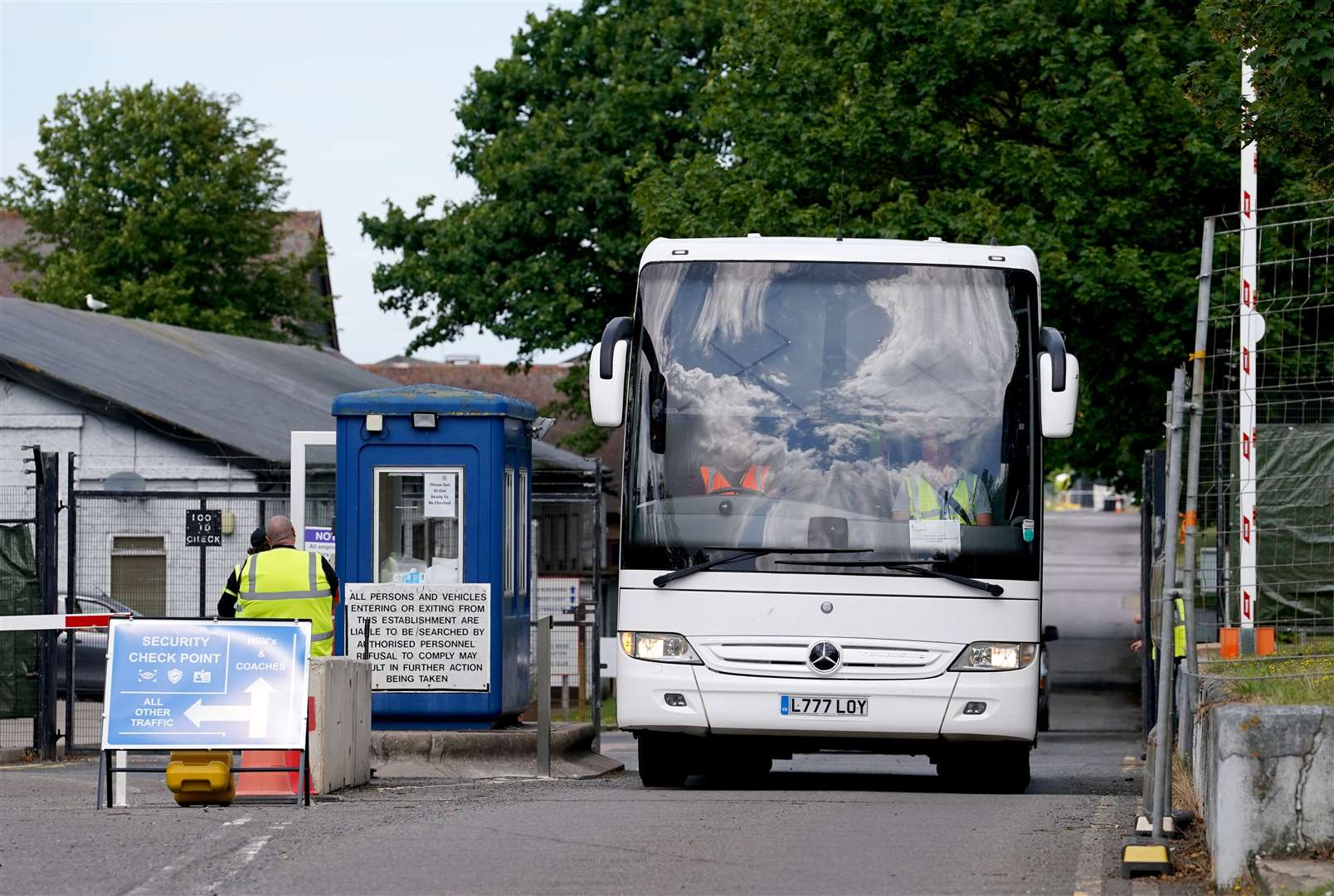 A coach carrying people thought to be migrants leaves Manston immigration short-term holding facility in Kent (Gareth Fuller/PA)