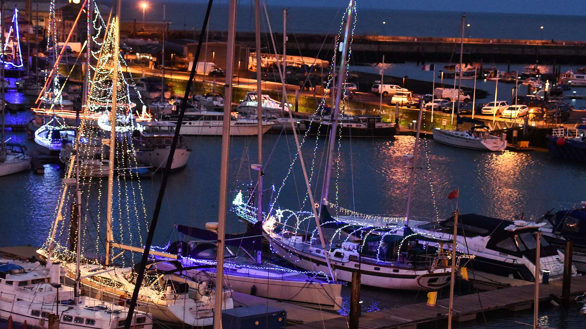 Boats in the harbour and marina lit up with Christmas lights