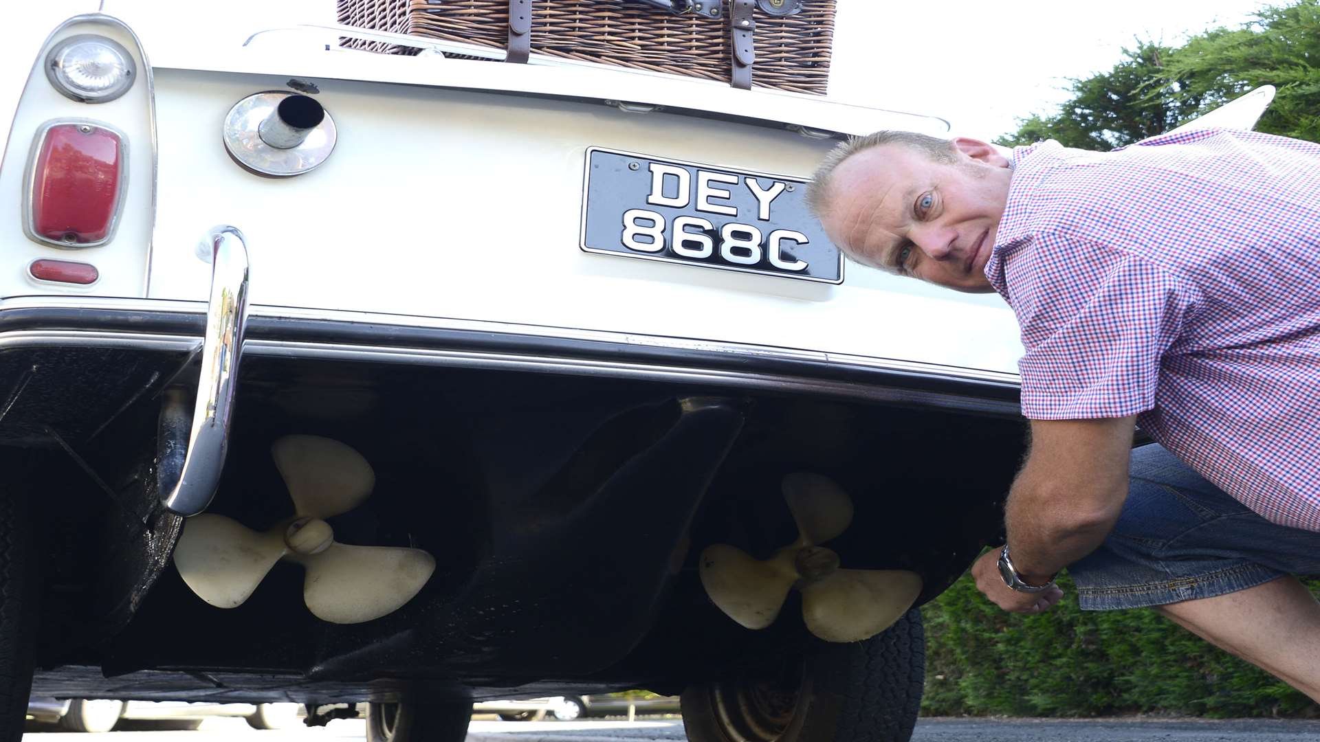 Kerry Cheese points out the propellars of his amphibious car
