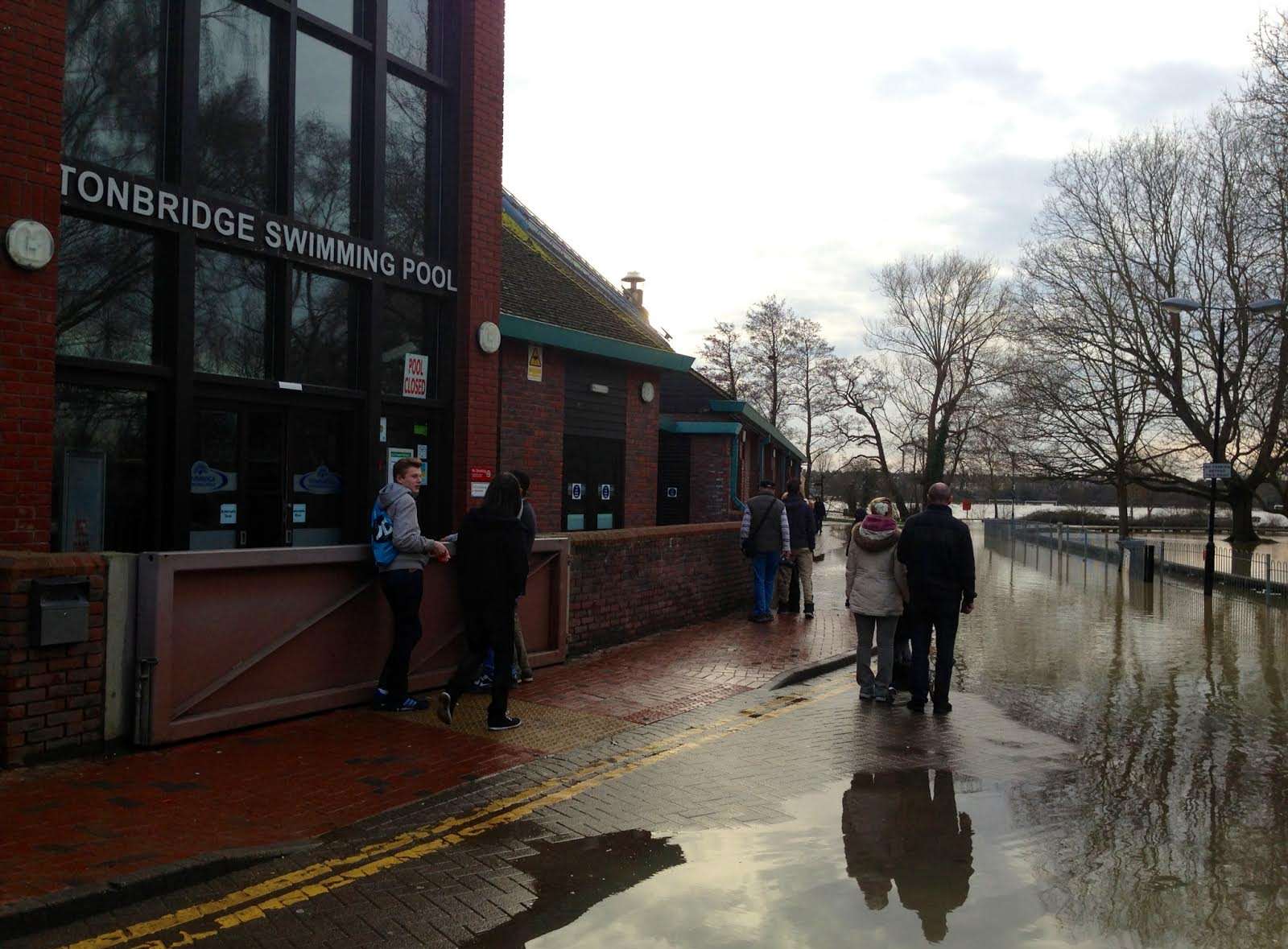 A flood gate is in place in front of Tonbridge Swimming Pool as onlookers survey the latest flood. Picture by Matthew Walker