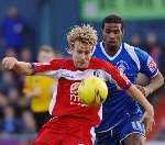 Danny Spiller holds the ball up under pressure from Oldham's Paul Edwards