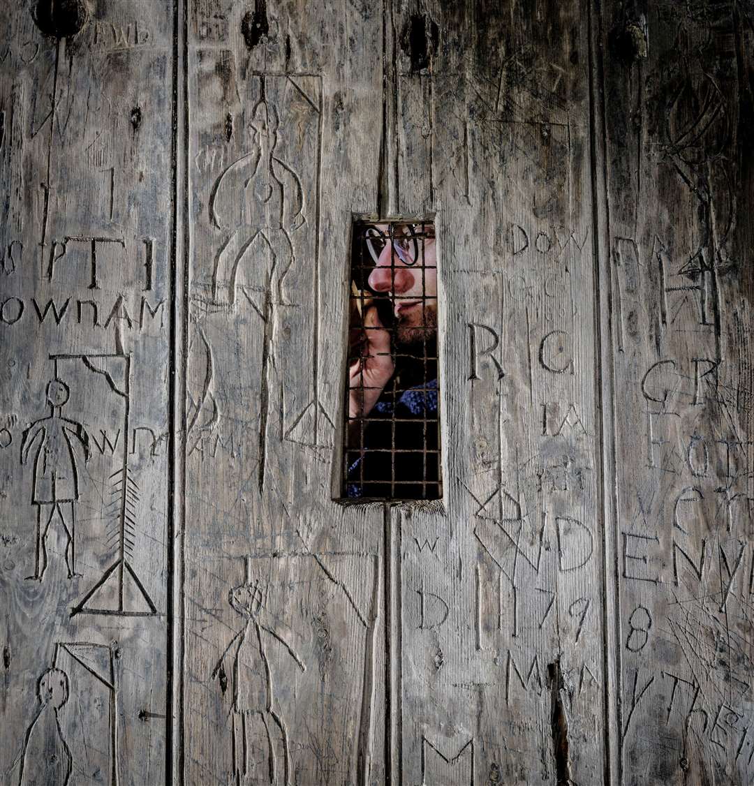 A sailing ship, the date of the French revolution (1789), nine macabre depictions of hangings, and countless initials feature on the door. Picture: English Heritage