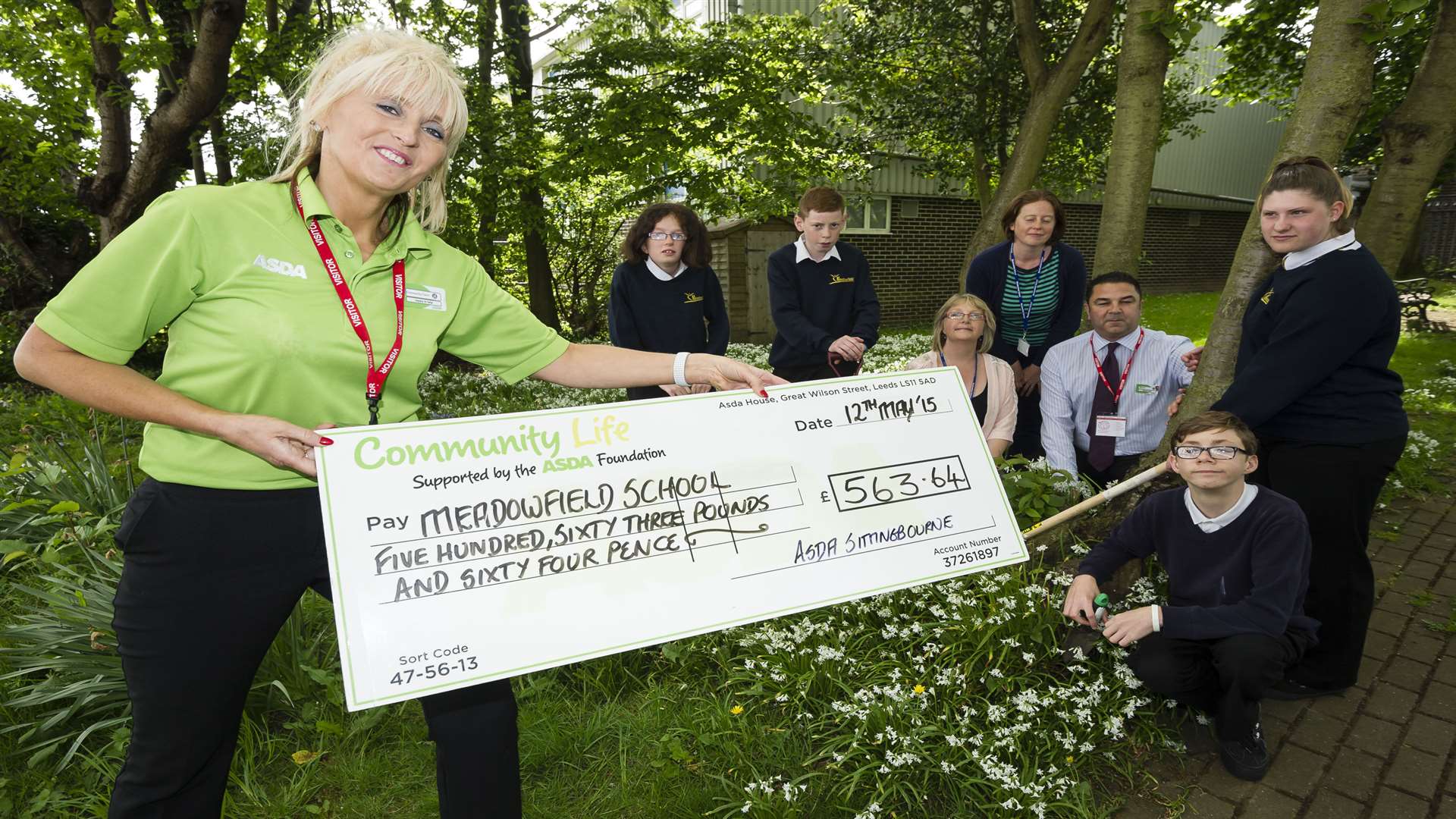 Asda's Claire Fosbeary presents a donation of more than £500 to the sensory garden project