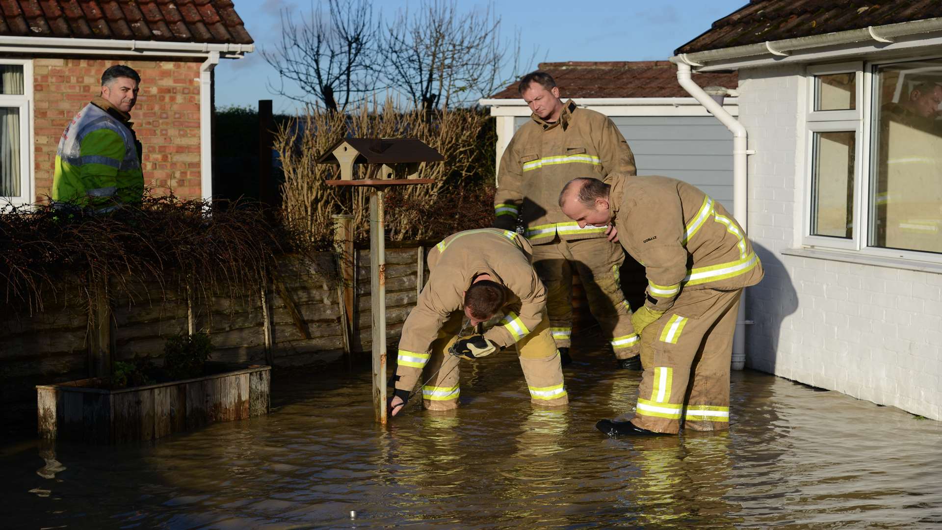 Firefighters tackle to pump some of the water from the front garden