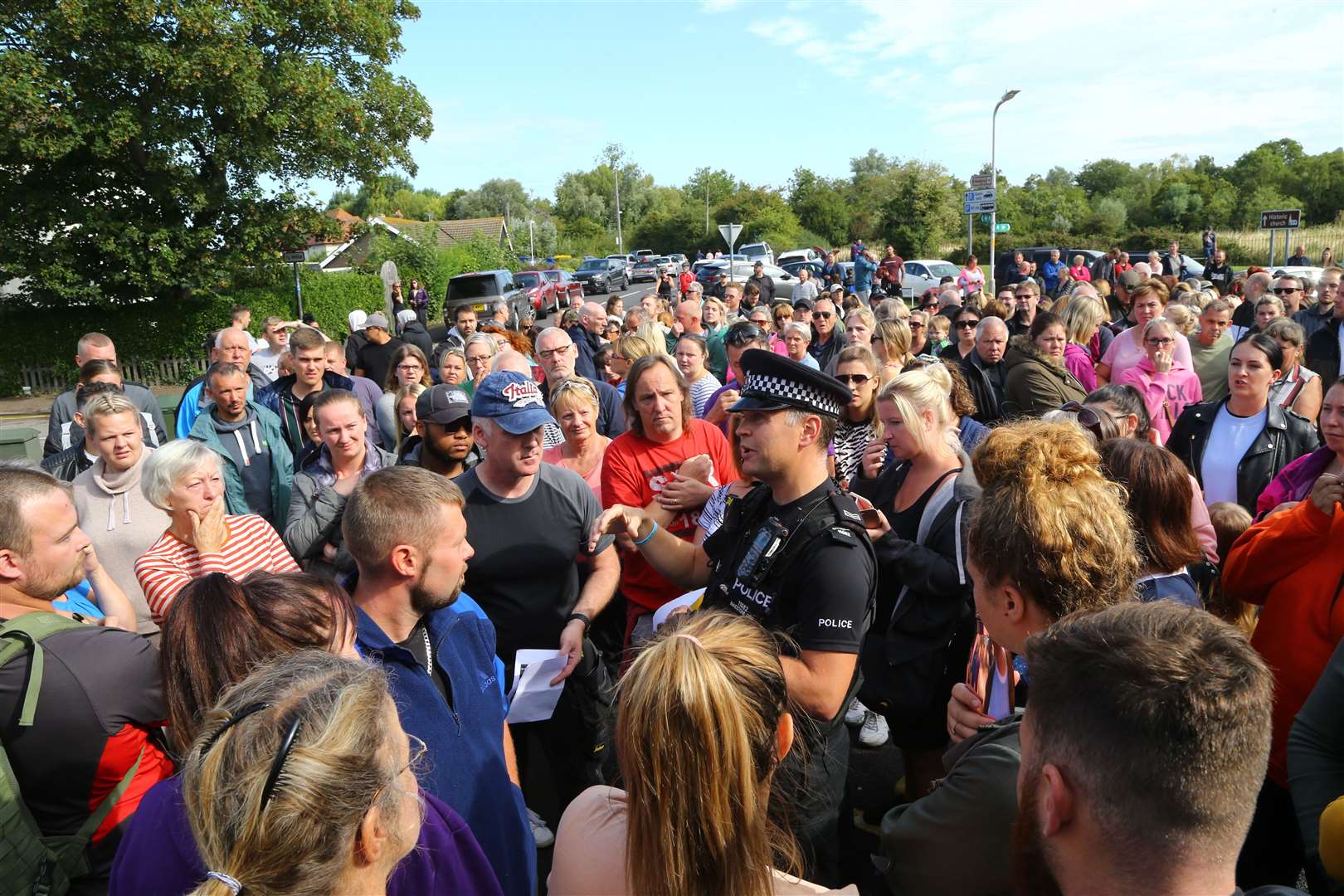 A police officer talks to members of the public gathered to join specialist search and rescue teams outside the fire station in Sandwich. Picture: PA Wire