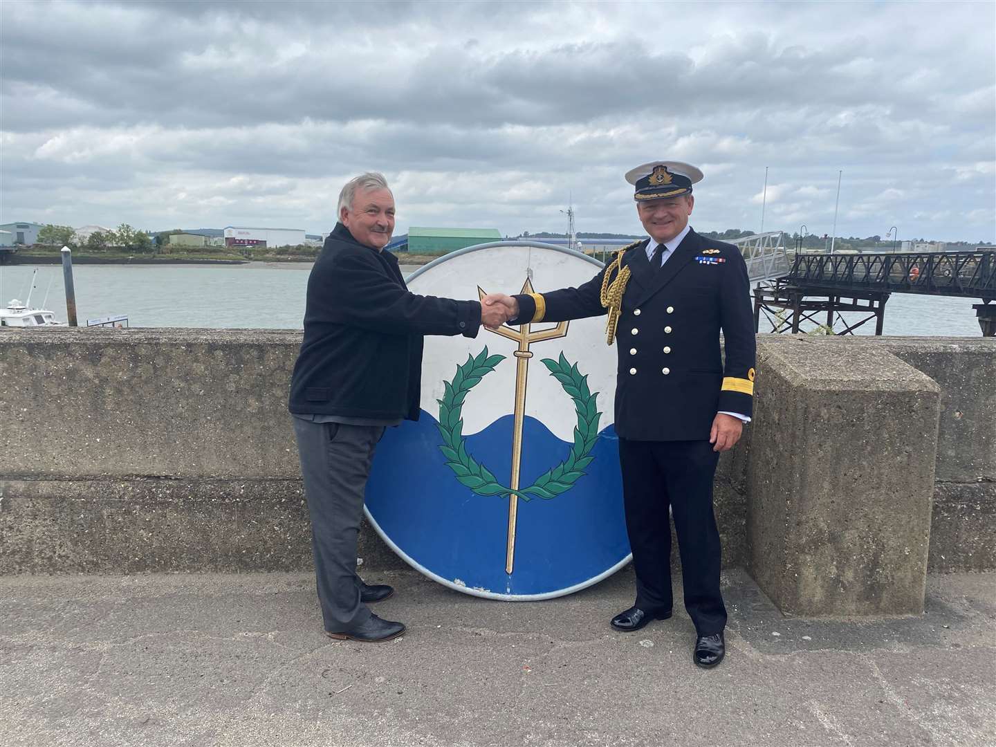 Cdre Rob Bellfield hands over one of the funnel badges from HMS Chatham, which he served on board twice, to Medway Council leader Alan Jarrett. They will be displayed at St George's Centre in Chatham on Tuesdays