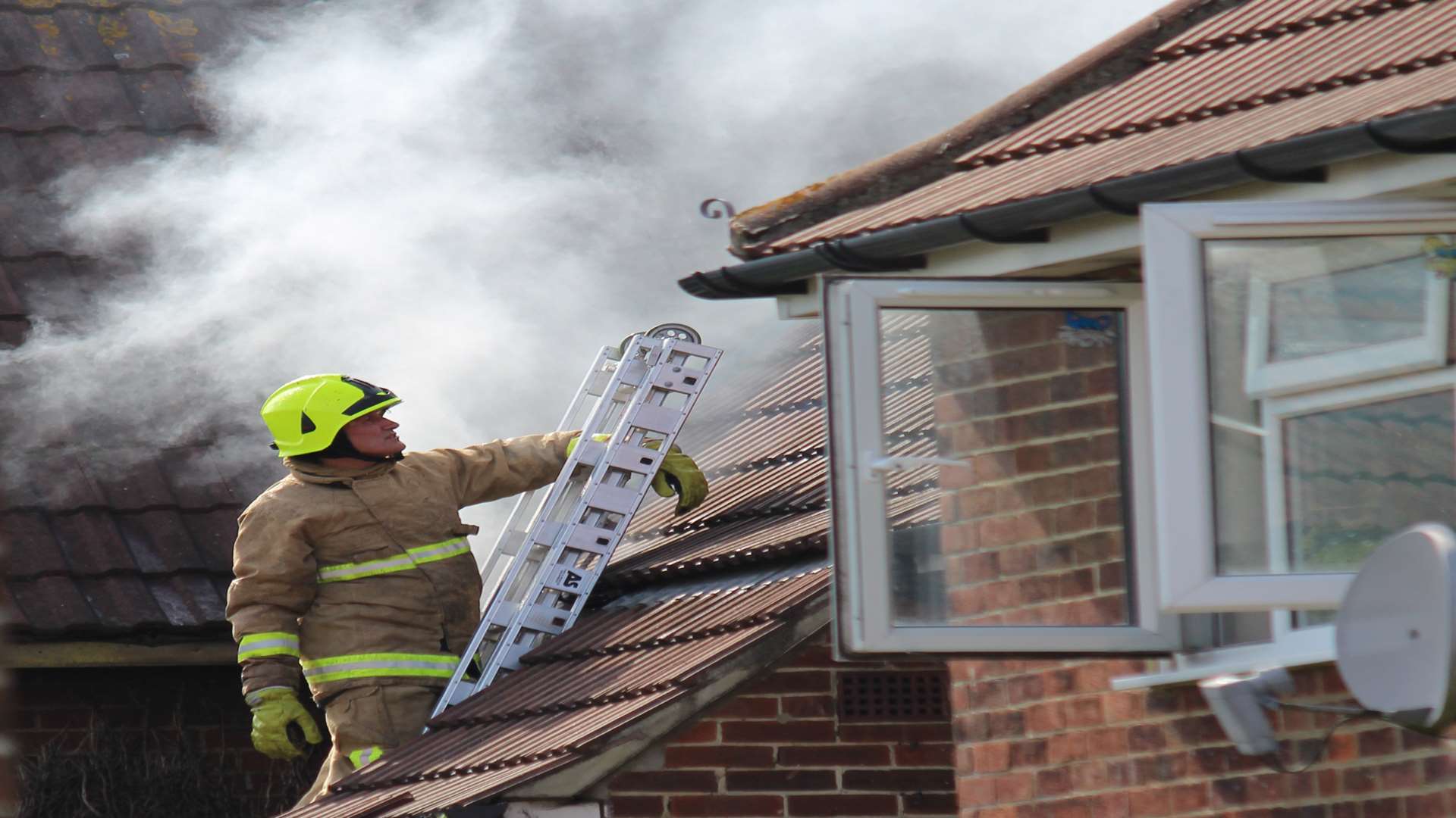 Firefighters scale a terraced house on fire in Whitfield