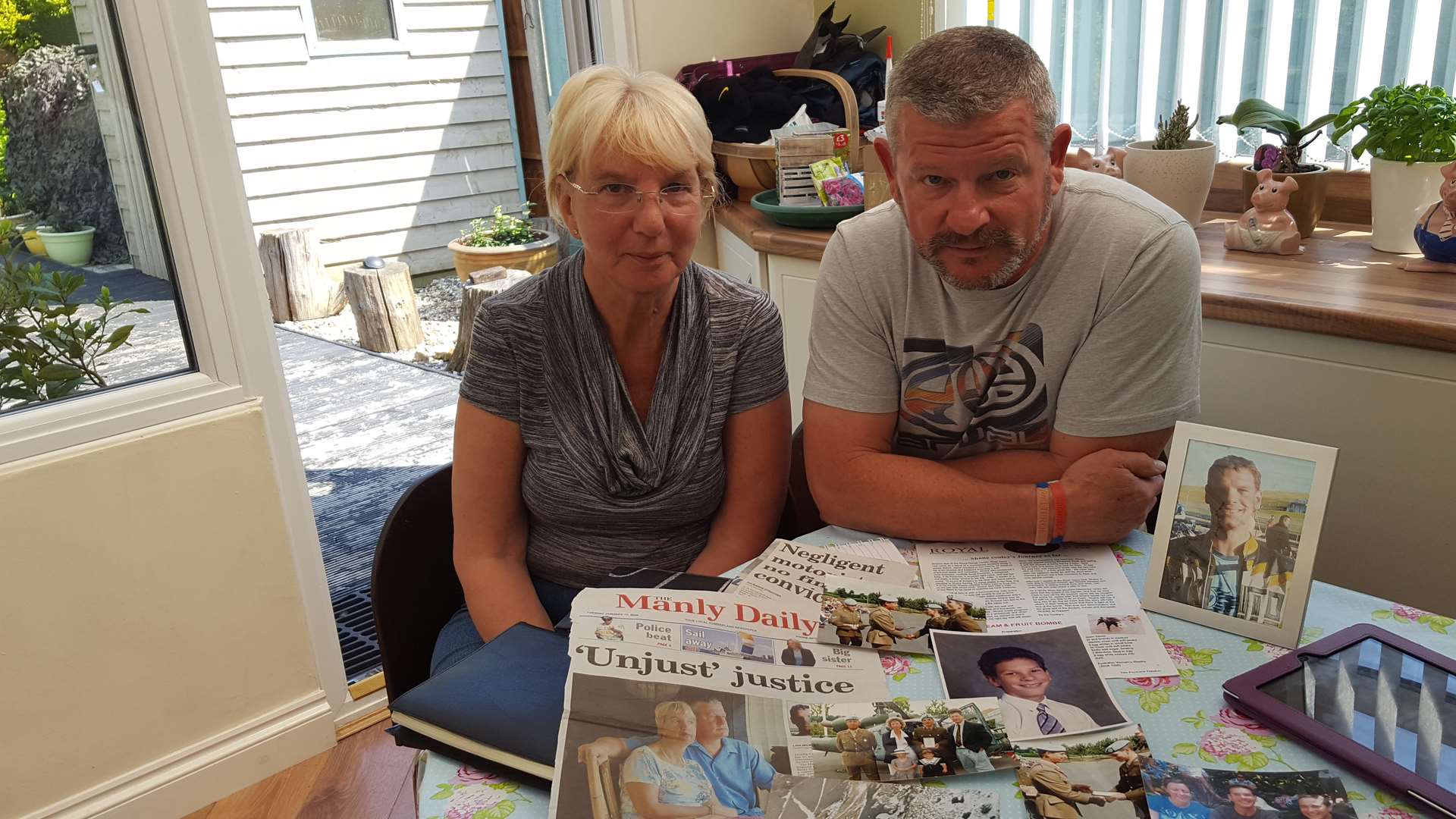 Sylvia and Peter Cooley with photographs and albums of their son Shane