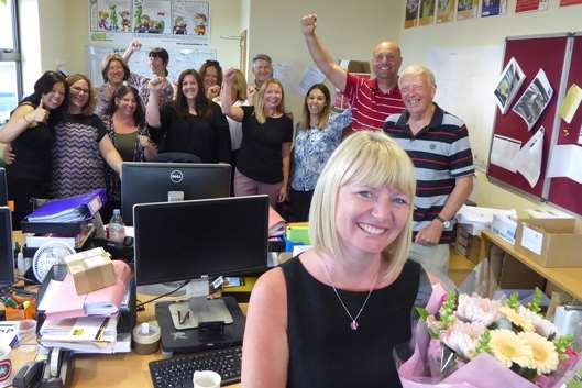 KM Charity Team Team Leader Karen Brinkman is presented with a bouquet to celebrate 10 years of service with the charity.