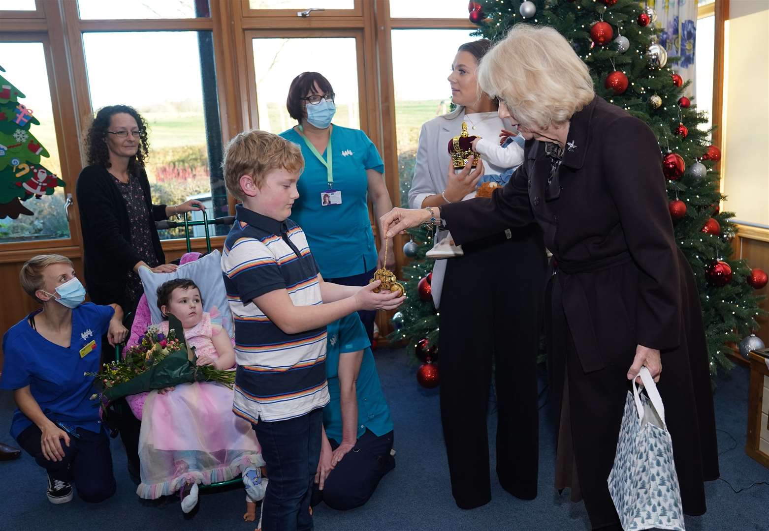 Camilla handing out tree decorations to families at the hospice (Jacob King/PA)