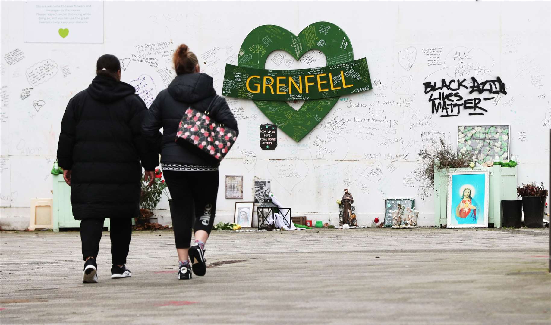 Two women are seen approaching a tribute to the Grenfell Tower fire. File image. (Jonathan Brady/PA)