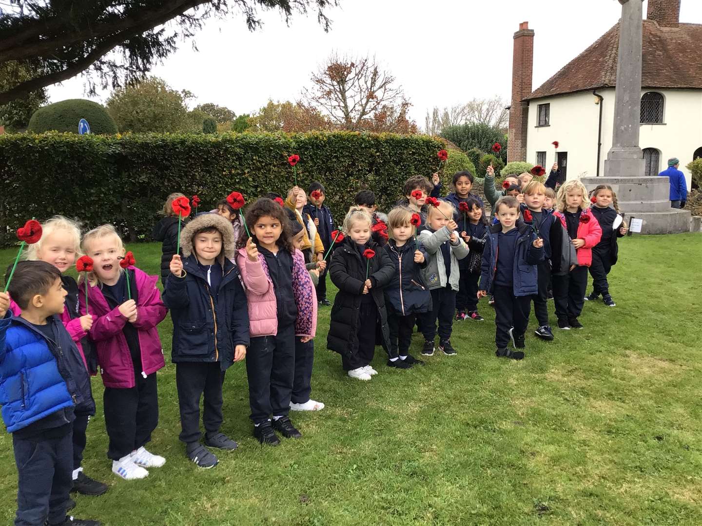 Hundreds of hand-knitted poppies were laid at Cobham War Memorial by school children