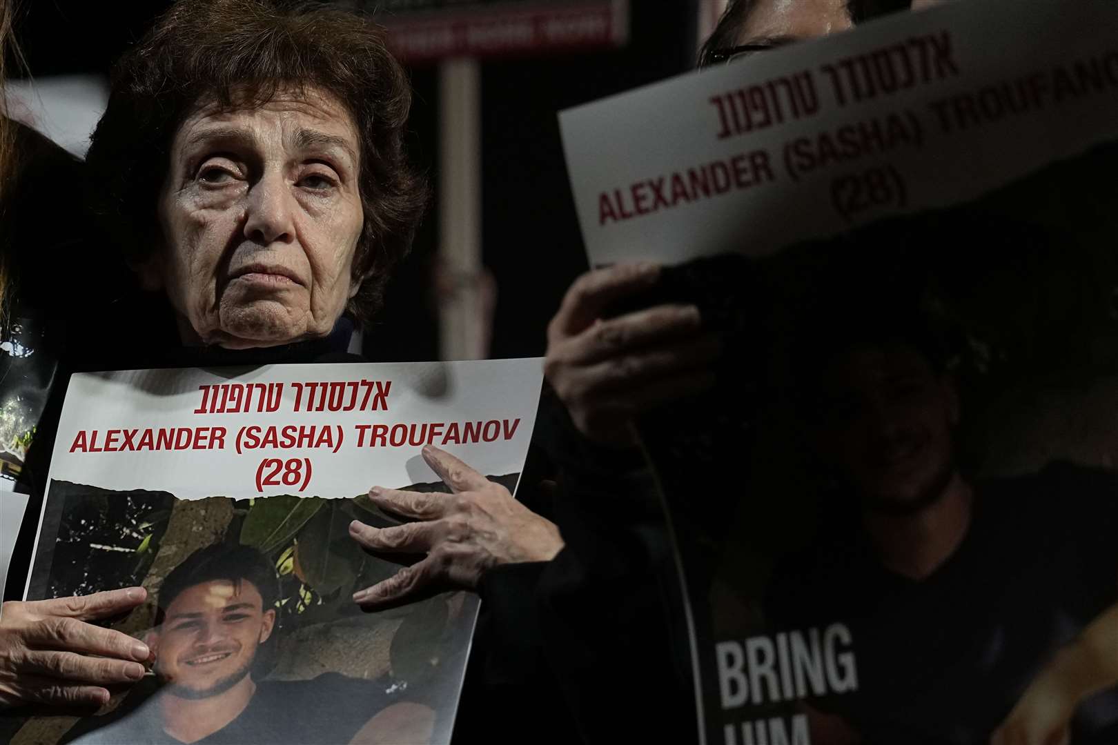 Irena Tati holds a picture of her grandson Alexander, held by Hamas in Gaza, during a demonstration to call for the release of hostages in the Hostages Square at the Museum of Art in Tel Aviv, Israel (Ariel Schalit/AP)