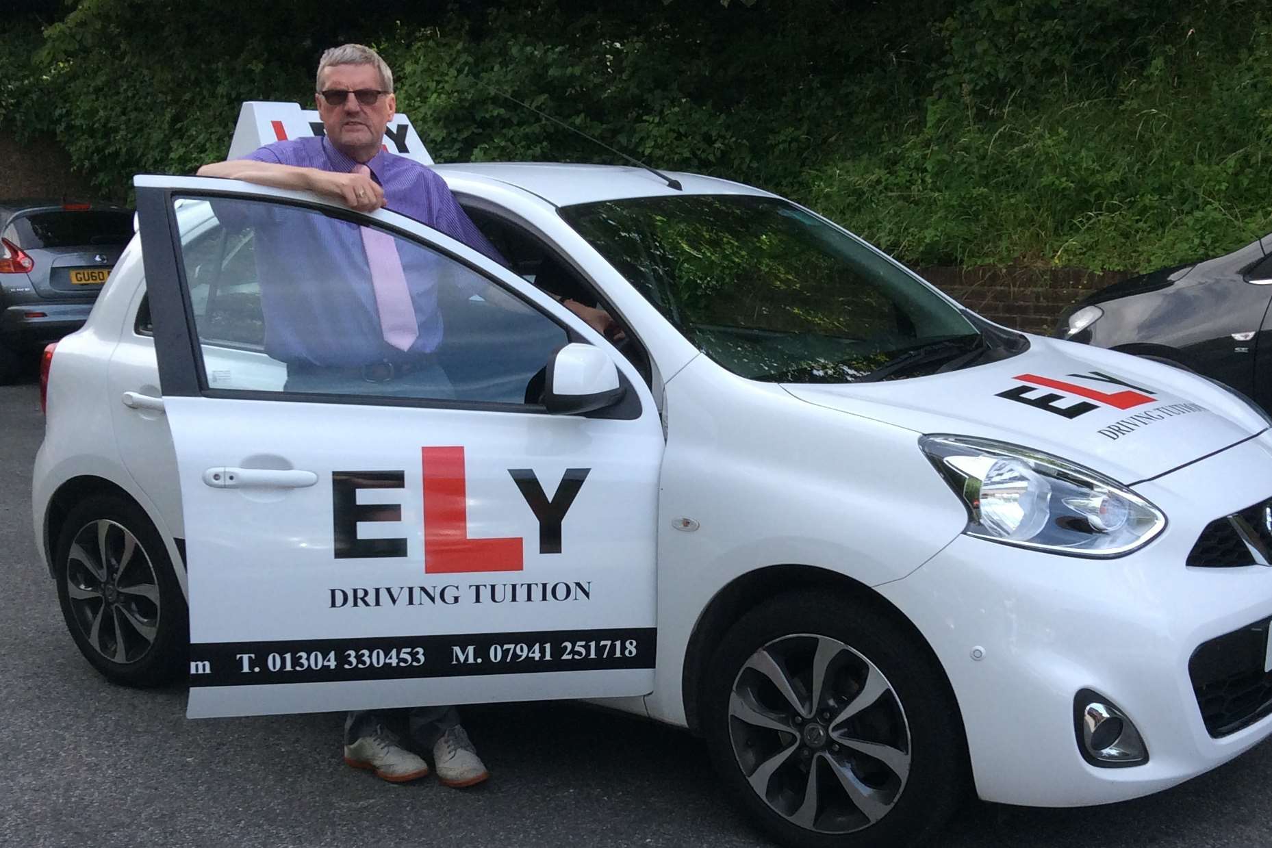 Driving instructor Malcolm Ely with the car attacked by yobs.