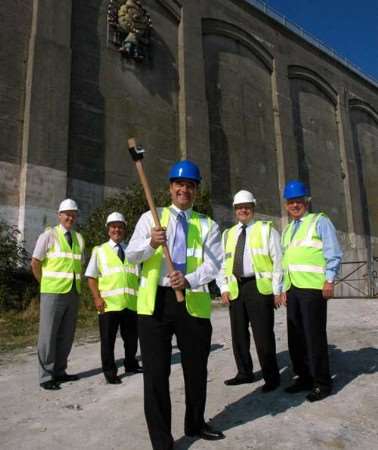 Cllr Sandy Ezekiel and a group of dignitaries symbolically swing a pickaxe to mark the start of work