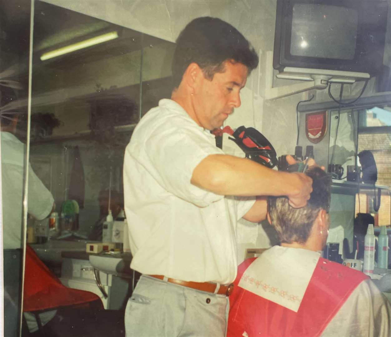 Undated photo of Phil working at the barbershop. Picture: Janette Miller