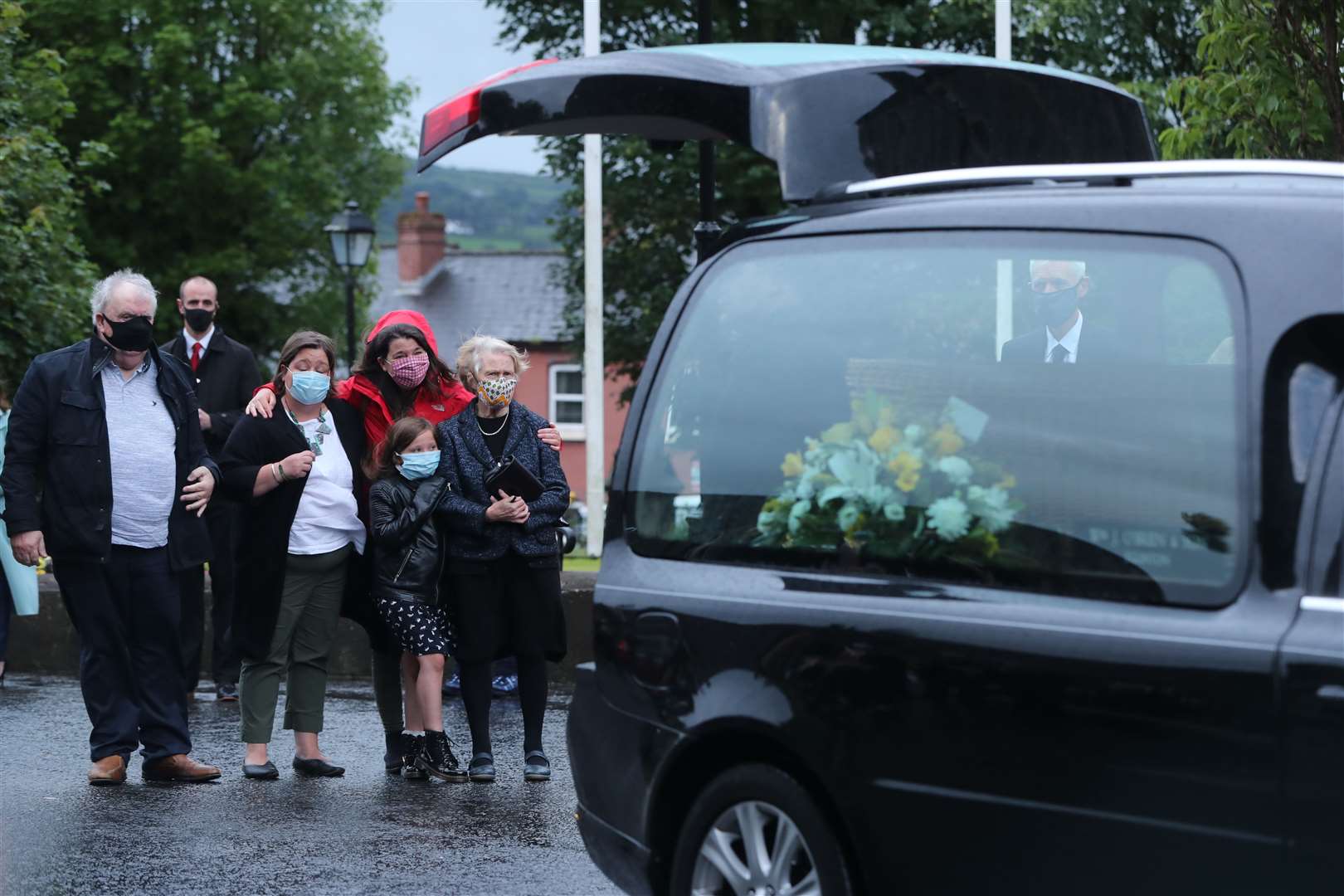 Family members watch as the coffin of John Hume is taken into St Eugene’s Cathedral in Londonderry (Niall Carson/PA)