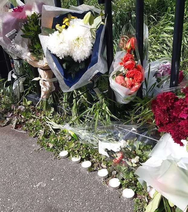 The community was left in shock with floral tributes left at the community centre in Temple Hill.