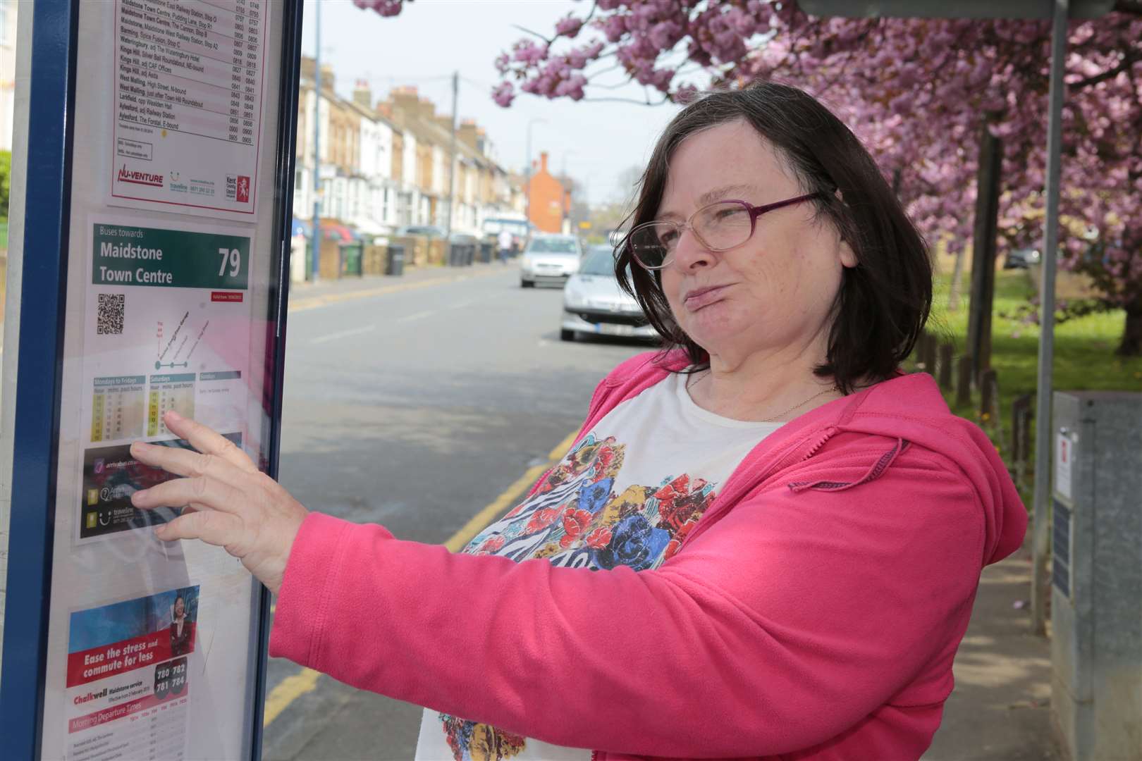 Lynda Clark at the bus stop where she can longer catch a bus home from work because the timetable has changed