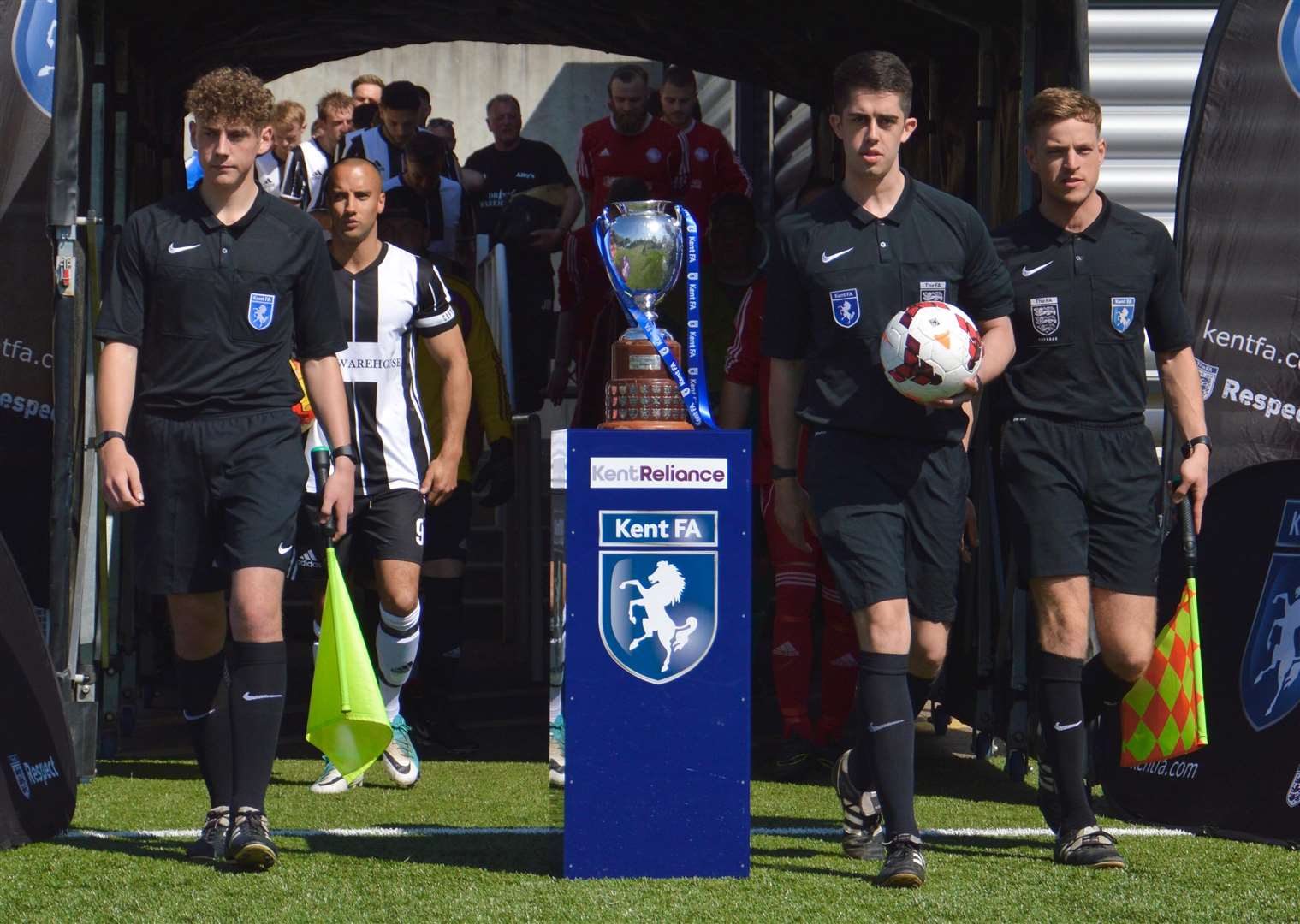 Match officials lead the teams out for a cup final at the Gallagher Stadium