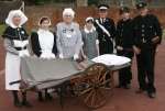 St John Ambulance Kent members wearing uniforms spanning from the 1890s to the 1990s pose with an old wheeled stretcher. Picture by John Weshtrop
