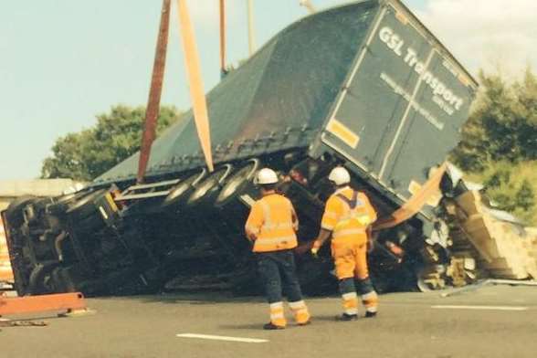 Rescue crews help to right the overturned lorry